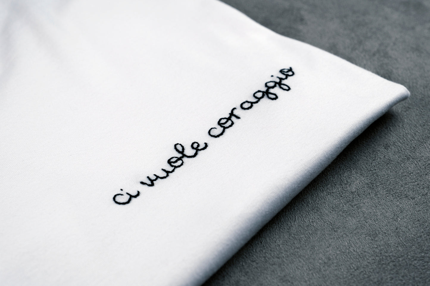 Dettaglio della T-shirt “CI VUOLE CORAGGIO”, la maglietta in 100% cotone è ricamata con la scritta "ci vuole coraggio"