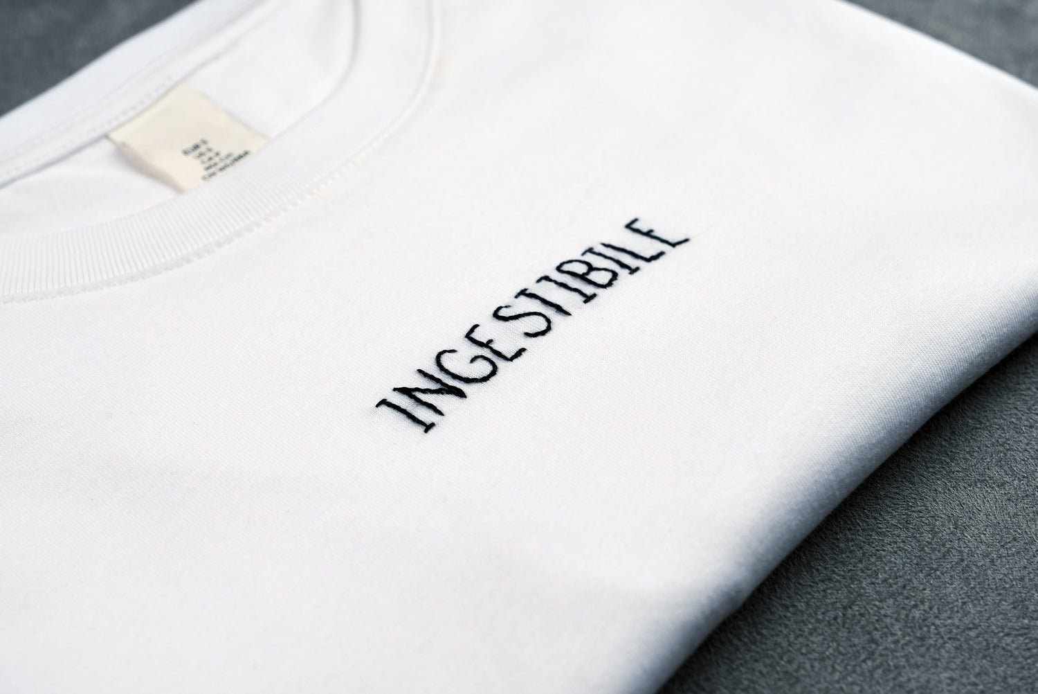 Dettaglio T-shirt “INGESTIBILE”, la maglietta in 100% cotone è ricamata con la scritta "ingestibile"