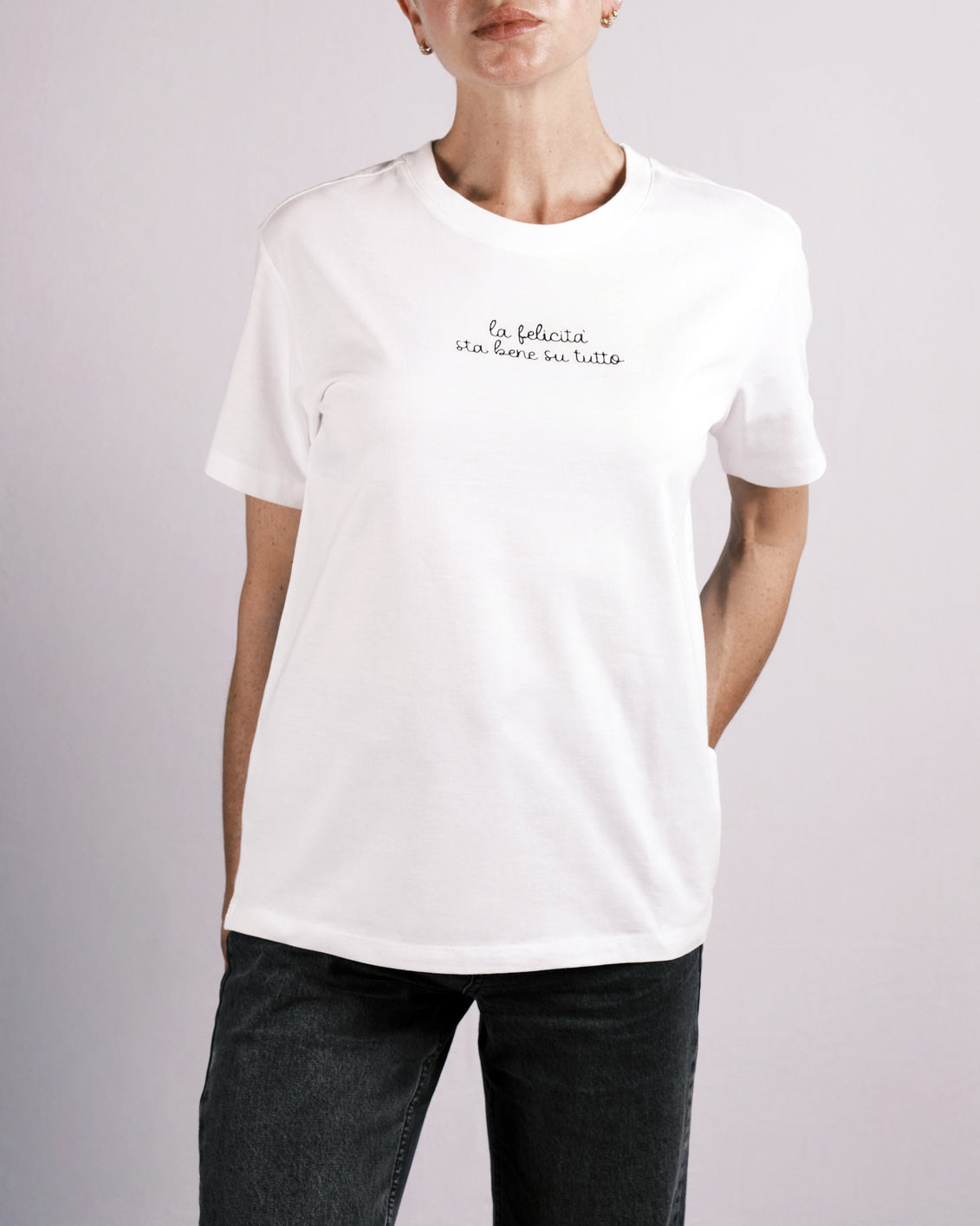 T-shirt “LA FELICITÀ STA BENE SU TUTTO” indossata, la maglietta in 100% cotone è ricamata con la scritta "la felicità sta bene su tutto"