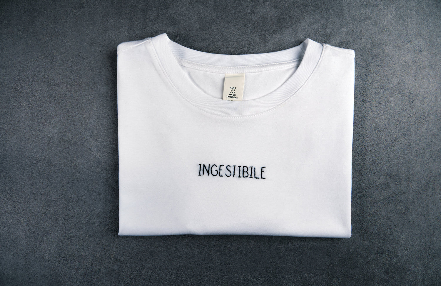 Dettaglio T-shirt “INGESTIBILE”, la maglietta in 100% cotone è ricamata con la scritta "ingestibile"